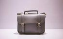 Bolsa satchel cinza com fivelas douradas